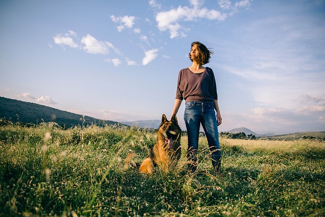 A woman and her service dog in the countryside. 